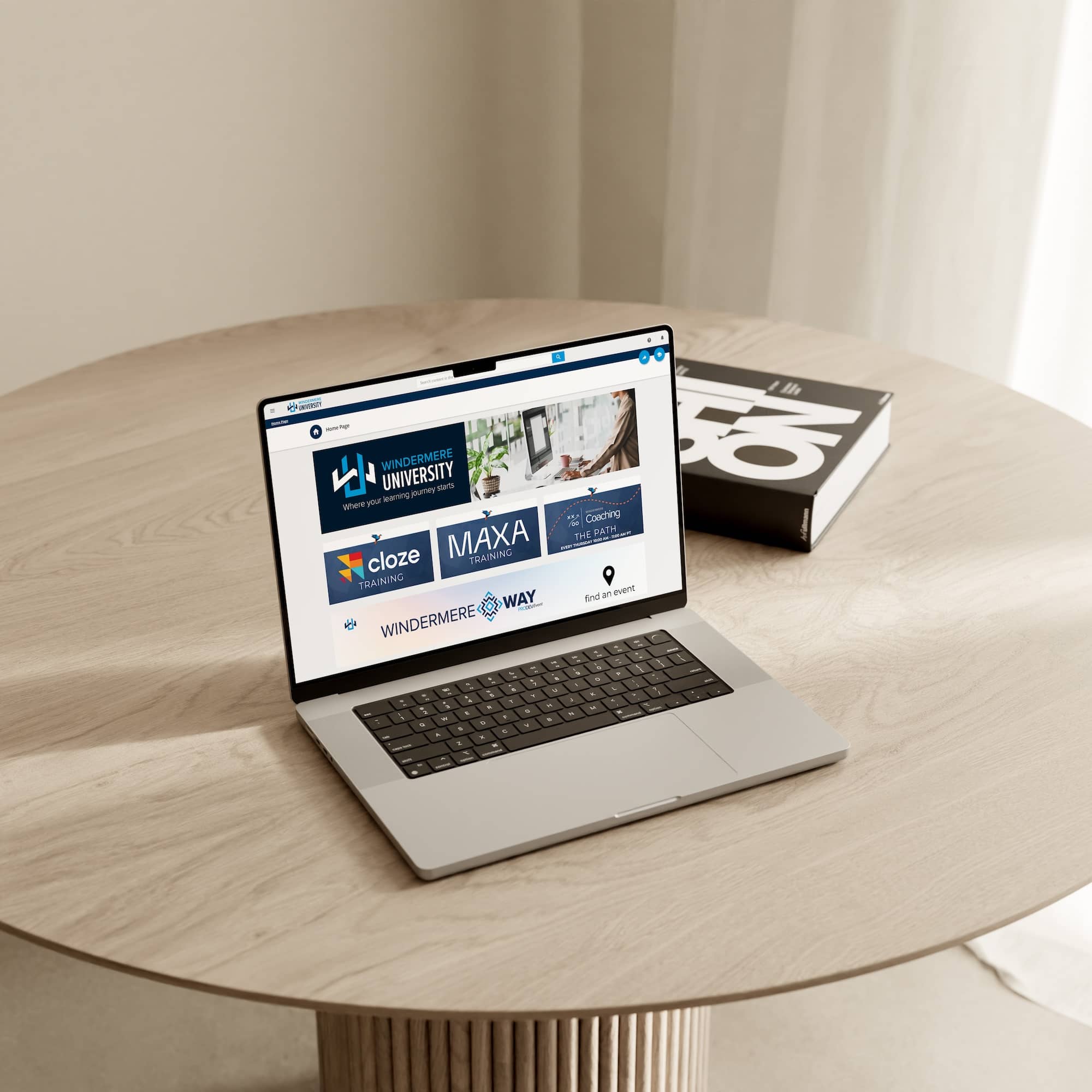 Laptop on a wood table showing the Windermere University online learning platform for real estate training.